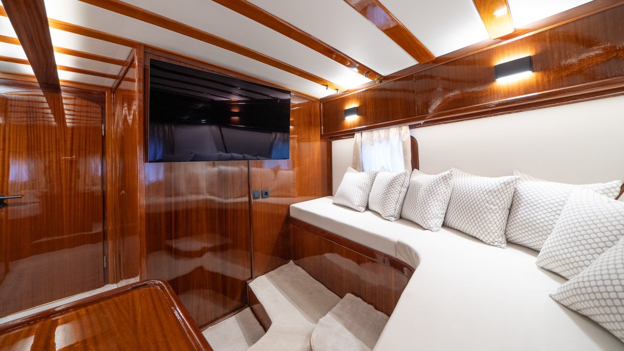 A cabin lounge inside of a yacht with a TV.