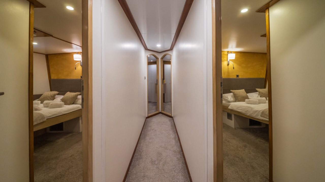 The hallway of a luxury yacht leading to multiple cabins.