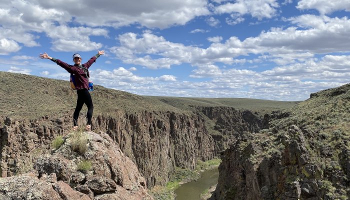A woman standing at an an overlook of the Owyhee river in Oregon. 