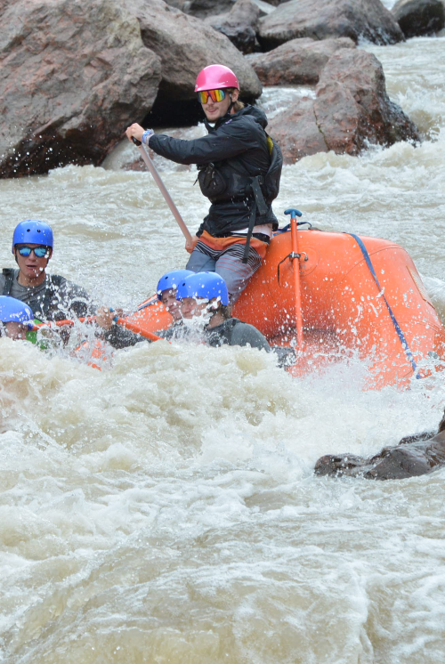 A river guide navigating a splashy rapid.